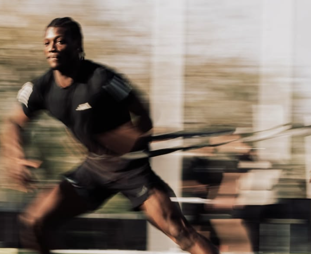An athlete sprinting against resistance during training
